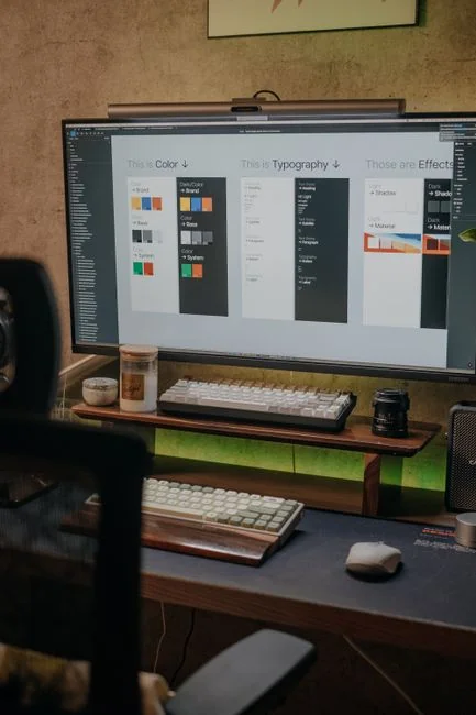 Un écran d’ordinateur portable affiche une application de programmation avec un design de calculatrice dans un environnement de bureau technologique.